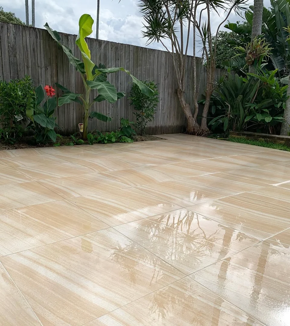 Camp Hill outdoor porcelain tiles in warm tones beside a tropical garden